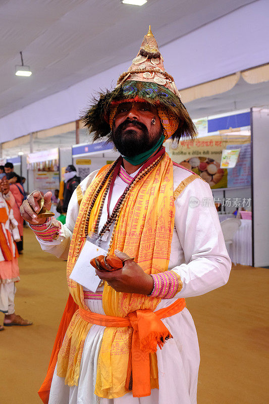 印度浦那- 2021年12月25日-瓦苏德夫(Vasudev)，一名印度教朝圣者，他们是毗湿奴(Lord Vishnu)的信徒，戴着一顶印有孔雀羽毛的锥形帽子。多年来，瓦苏德夫一直是马哈拉施特拉邦的传统这些朝圣者四处游荡，歌颂维斯神